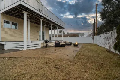 The backyard with a charcoal grill and wood burning fire pit!