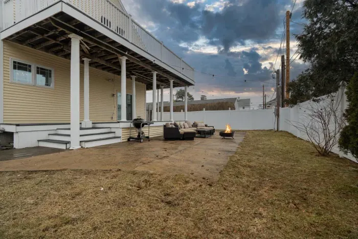 The backyard with a charcoal grill and wood burning fire pit!