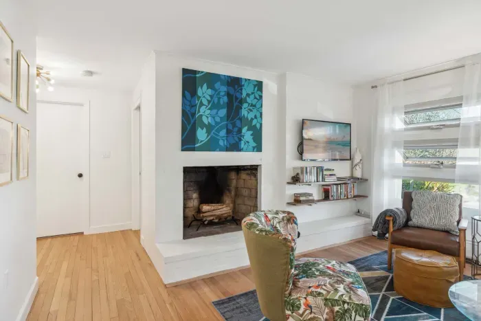 The living room with 3 chairs, a comfy 3 seater couch, and smart TV! Please note - the fireplace is inoperable