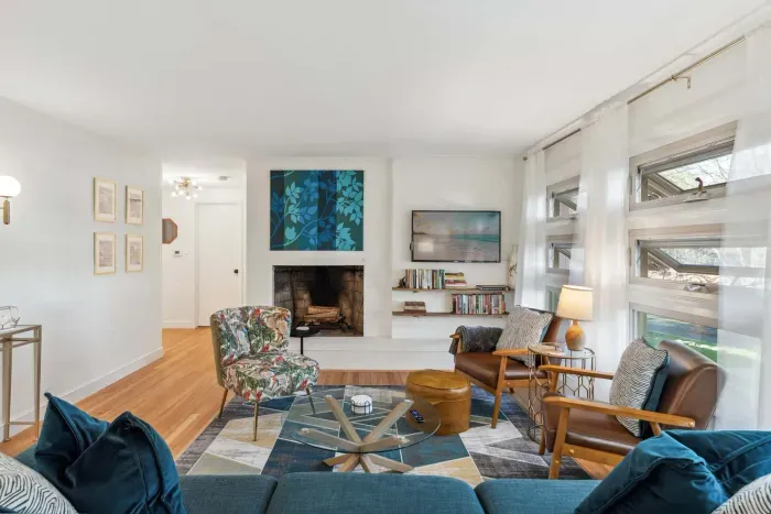 The living room with 3 chairs, a comfy 3 seater couch, and smart TV! Please note - the fireplace is inoperable