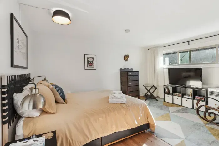 Bedroom #2 with a queen bed! Plenty of storage with a dresser and closet. Smart TV and rocking chair! Clean linens provided