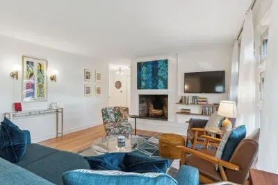 The living room with 3 chairs, a comfy 3 seater couch, and smart TV! Please note - the fireplace is inoperable
