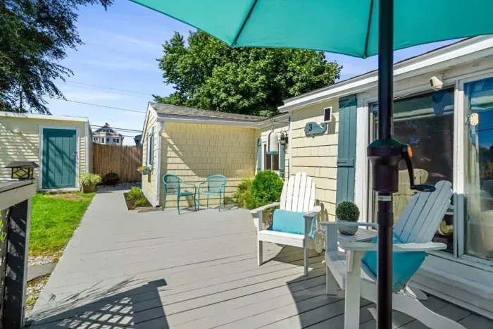 Front deck with outdoor couch, umbrella, and Adirondack chairs
