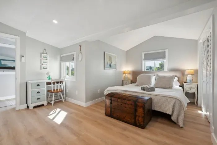 Primary bedroom with a king bed, Roku smart TV, desk, and access to the side deck