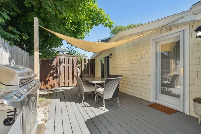 Side deck with outdoor dining table and grill.