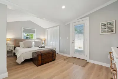 Primary bedroom with a king bed, Roku smart TV, desk, and access to the side deck