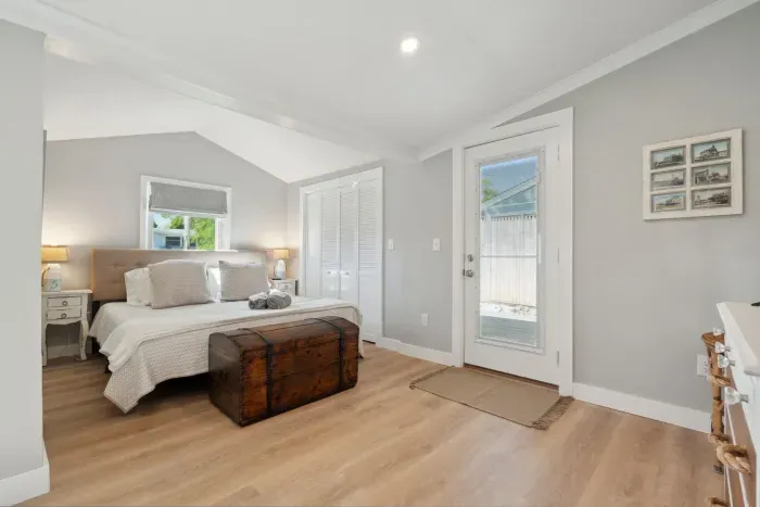 Primary bedroom with a king bed, Roku smart TV, desk, and access to the side deck