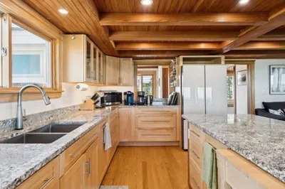 Open concept kitchen and living room with large windows to enjoy plenty of natural light.