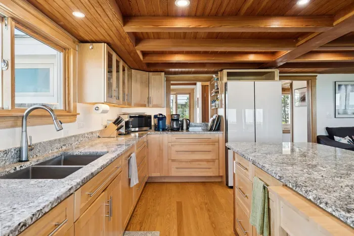 Open concept kitchen and living room with large windows to enjoy plenty of natural light.