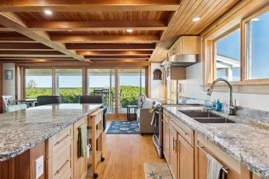 Open concept kitchen and living room with large windows to enjoy plenty of natural light.