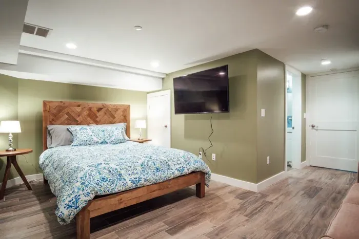 Bedroom #2 with en-suite full bathroom, flat screen TV and couch.