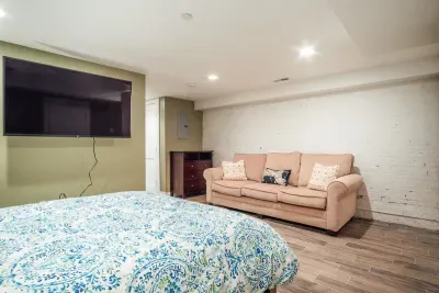 Bedroom #2 with en-suite full bathroom, flat screen TV and couch. NOTE: The couch has been replaced with a twin day bed.