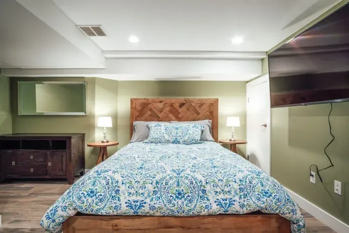 Bedroom #2 with en-suite full bathroom, flat screen TV and couch.