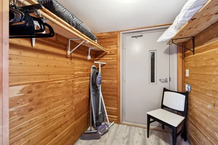 Large closet equipped with hangers, iron, and ironing board
