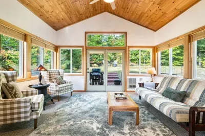 The sunroom, located off the great room. PLEASE NOTE - this is the sleeping accommodation for the 8th guest. There is a dedicated workspace in here (see other pictures) and futon that lays flat. There is access to the backyard from this room.
