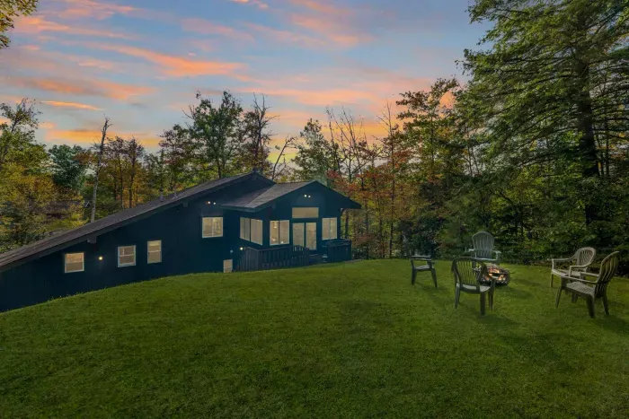 The backyard, featuring a firepit with chairs and small deck for grilling!