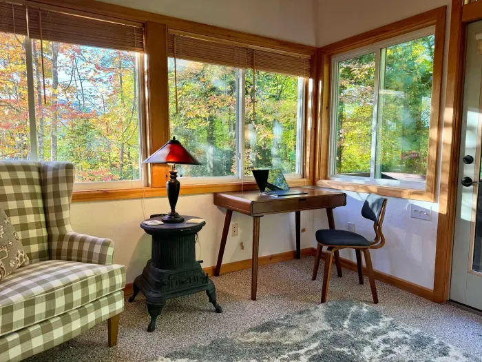 Dedicated workspace in the sunroom. This room has pocket doors that close it off to the rest of the house. The chair in the previous picture is now located in the bunk room. Check out this old woodstove as a side table!