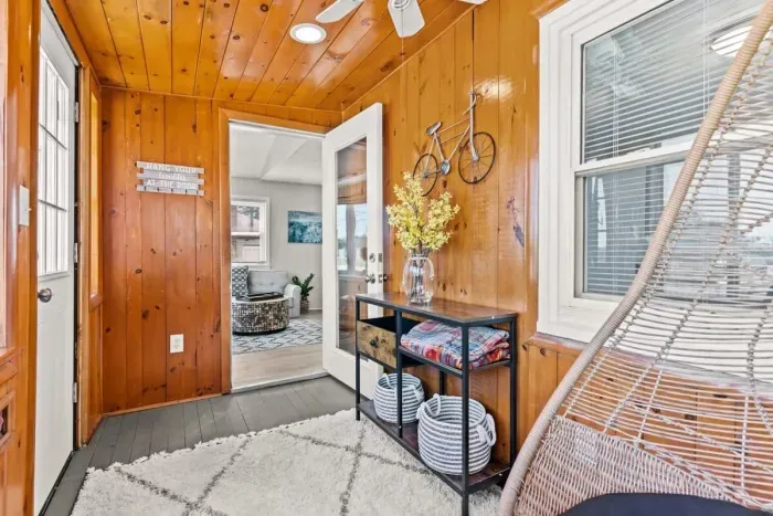 Front sun room with swing chair, perfect for reading or enjoying a drink.