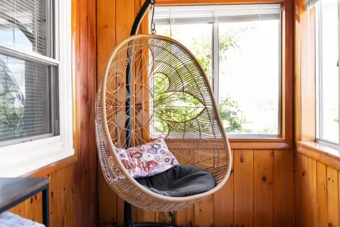 Front sun room with swing chair, perfect for reading or enjoying a drink.
