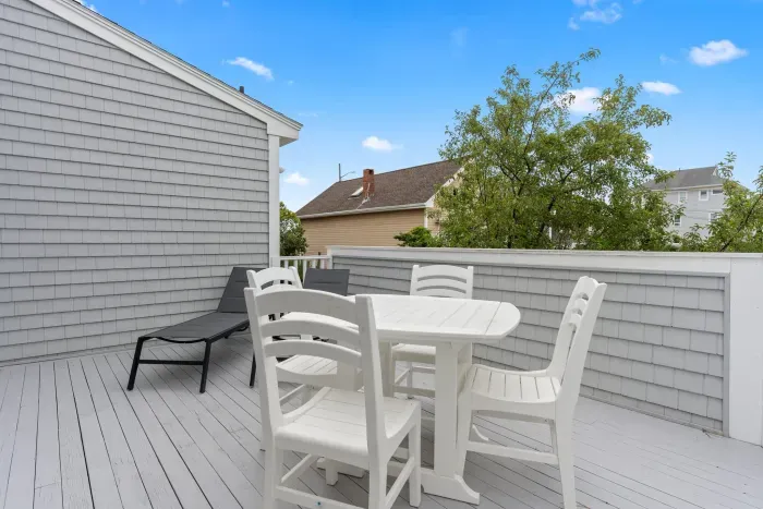 Spacious back deck with dining set and lounging chairs off the kitchen