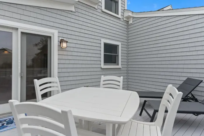 Spacious back deck with dining set and lounging chairs off the kitchen