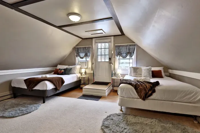 Two queen beds with Roku TV and kitchenette area.