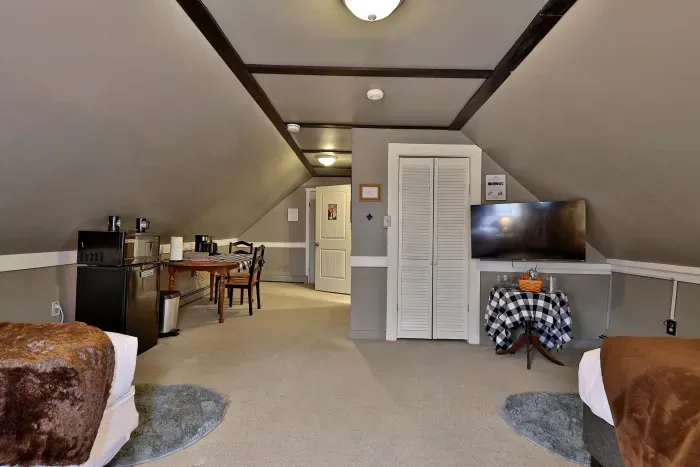 Two queen beds with Roku TV and kitchenette area.