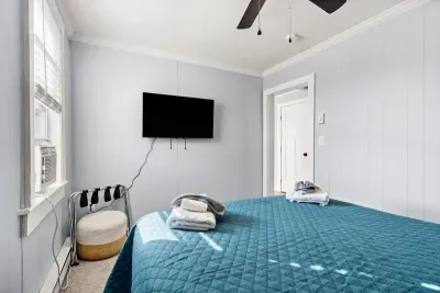 Bedroom #1 with queen bed, and mounted flatscreen smart Roku TV