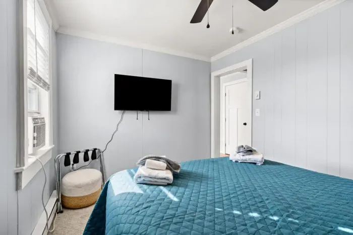 Bedroom #1 with queen bed, and mounted flatscreen smart Roku TV