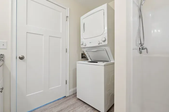 Ensuite bathroom with double vanity, standing shower, and in-unit washer dryer