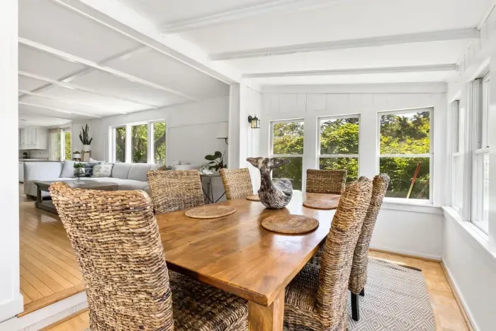 Step into the coastal dining area with seagrass chairs and tons of natural light provided by a surround of windows!