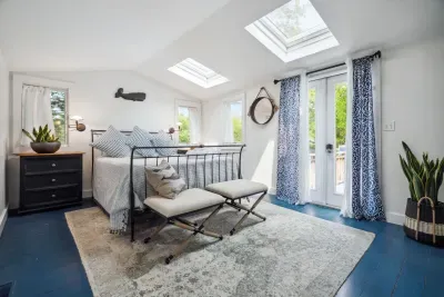 Wind down after a day at the beach watching the trees and stars through the skylights. This primary bedroom with a queen bed and clean provided linens will make you feel right at home.