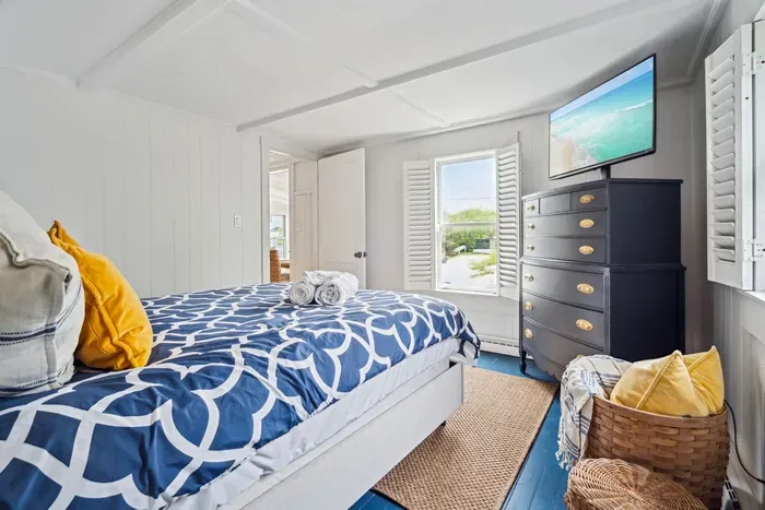 The third bedroom, located at the back corner of the home. This room has a smart TV and a queen bed with clean provided linens.