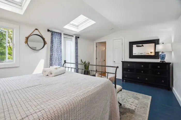 Wind down after a day at the beach watching the trees and stars through the skylights. This primary bedroom with a queen bed and clean provided linens will make you feel right at home. 