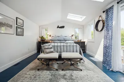 Wind down after a day at the beach watching the trees and stars through the skylights. This primary bedroom with a queen bed and clean provided linens will make you feel right at home.