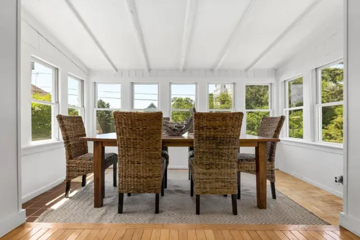 Step into the coastal dining area with seagrass chairs and tons of natural light provided by a surround of windows!