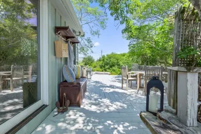 This thoughtful outdoor space with the upper stone patio and deck area offer plenty of space for everyone to roam around. Access to the kitchen is right off this slider.