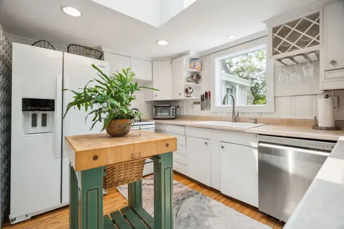 There is a dishwasher in this kitchen, plenty of plates, cups, utensils and more! The full size range is located behind this butcher block