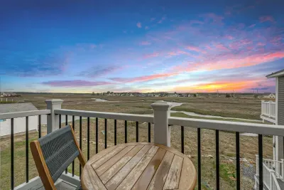 Small second floor balcony with 2-seater outdoor table. Featuring unobstructed views of the salt marsh