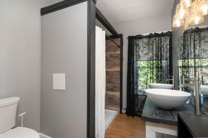 1st bedroom ensuite full bathroom with double vanity and provided hand soap, shampoo, body wash and towels