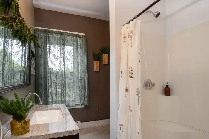 2nd bedroom ensuite full bathroom with provided hand soap, shampoo, body wash and towels