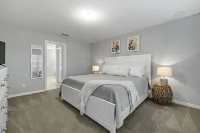 Primary bedroom with king bed, 2 walk-in closets, smart flatscreen TV and ensuite bathroom with tiled shower.