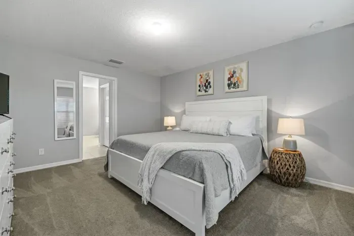 Primary bedroom with king bed, 2 walk-in closets, smart flatscreen TV and ensuite bathroom with tiled shower.