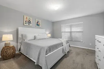 Primary bedroom with king bed, 2 walk-in closets, smart flatscreen TV and ensuite bathroom with tiled shower.