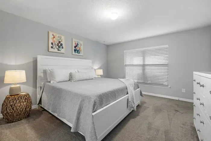 Primary bedroom with king bed, 2 walk-in closets, smart flatscreen TV and ensuite bathroom with tiled shower.