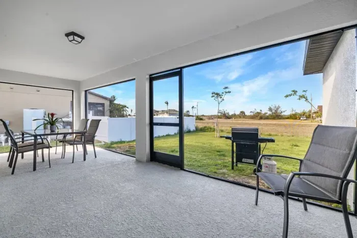 Screened-in Lanai, outdoor dining table, and plenty of outdoor space in both the front and back of out home. (Gas grill no longer on property)