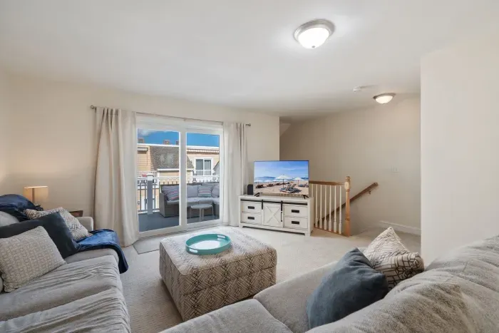 Living room with balcony out of sliders. Smart TV