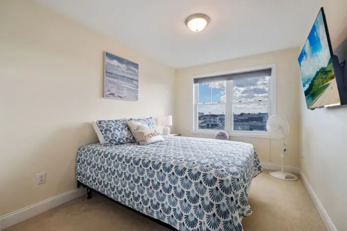 Bedroom #3 upstairs with queen bed, provided linens, and smart TV