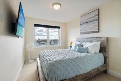 Bedroom #2 upstairs with queen bed, provided linens, and smart TV