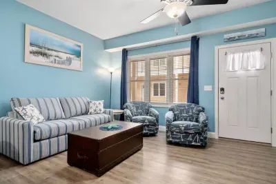 Open living room & kitchen with sleeper sofa, mounted smart TV, strong WiFi and fully-equipped kitchen